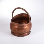 A COPPER COAL SCUTTLE, EARLY 20TH CENTURY Of helmet form raised on a circular plinth base, the brass