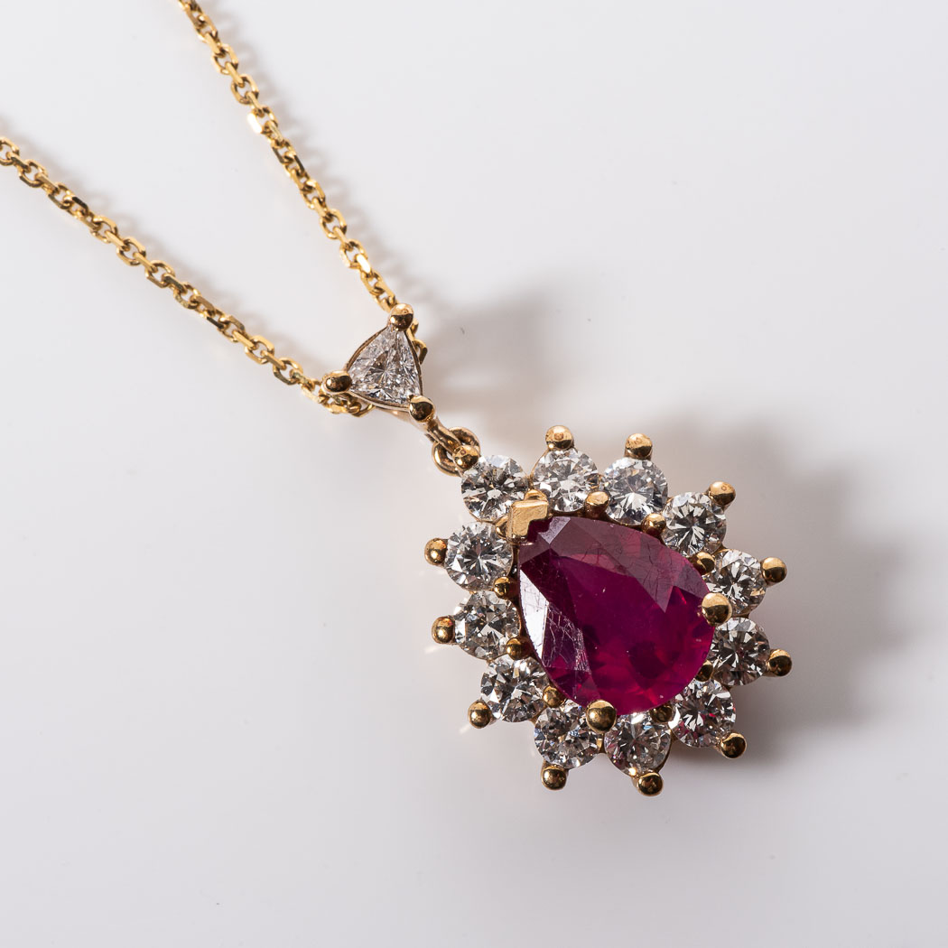 A RUBY AND DIAMOND PENDANT Claw set to the centre with an oval cut Ruby weighing 1,60 carats