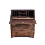 AN OAK BUREAU, 19TH CENTURY With a carved fall front, revealing a fitted interior supported by