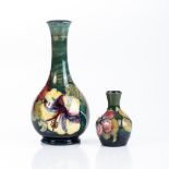 A MOORCROFT 'HIBISCUS' PATTERN BOTTLE VASE, MID 20TH CENTURY On a washed green ground, 21cm high;