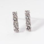 A PAIR OF DIAMOND EARRINGS Each claw-set as an articulated row of diamonds with a combined weight of