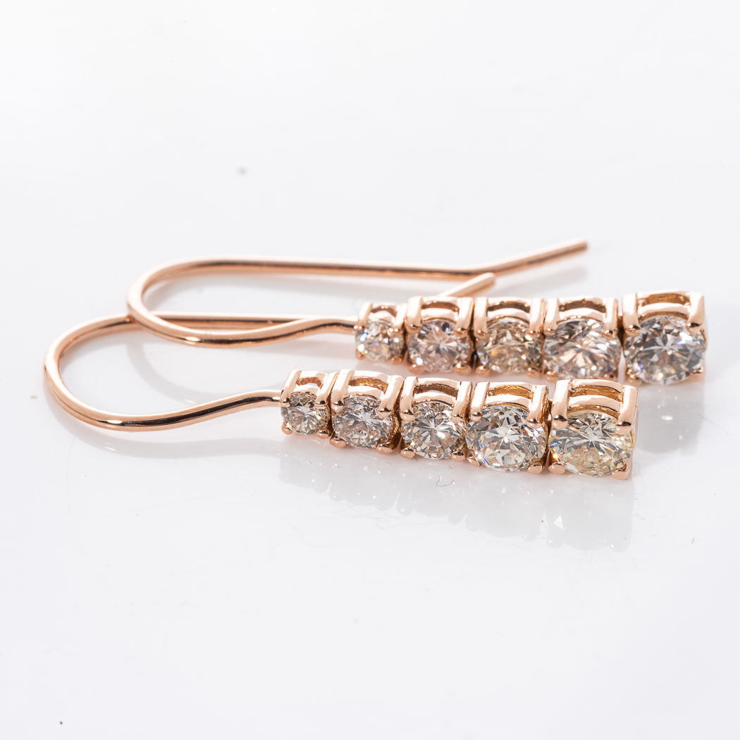 A PAIR OF DIAMOND EARRINGS Each claw set as an articulated row of tapered diamonds with a combined