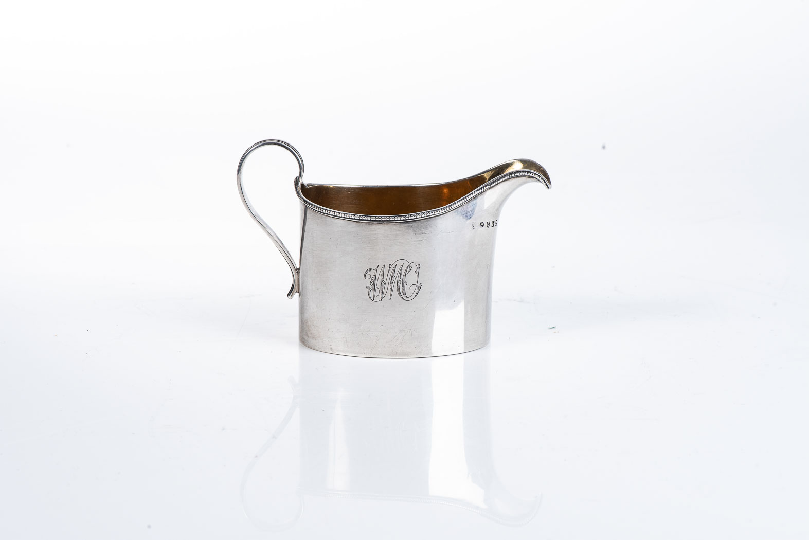 A GEORGE III SILVER CREAMER, MAKER'S MARK RUBBED, LONDON 1801 Beaded rim, reeded handle, gilt
