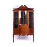 AN EDWARDIAN MAHOGANY AND INLAID DISPLAY CABINET The broken swan-neck pediment above a convex