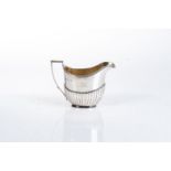 A GEORGE III SILVER MILK JUG, POSSIBLY JOHN EMES, LONDON 1803 Reeded rim and handle, gadrooned body,