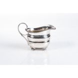 A GEORGE III SILVER CREAMER, ABSTINADO KING, LONDON, 1813 Gadrooned rim, reeded open handle,