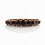 A GOLD BROOCH Bezel set to the centre with nine oval cut Garnets, 9ct rose gold circa 1950s