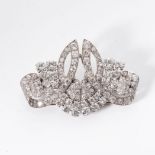 A PLATINUM BROOCH Designed as an open-work panel with swirls and sconces claw-set with 12,01cts of