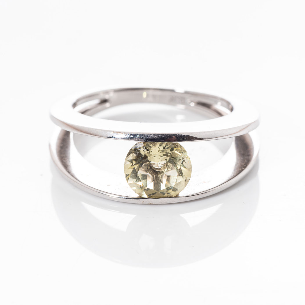 AN 18CT WHITE GOLD DRESS RING Tension-set to the centre with a round brilliant-cut lemon quartz