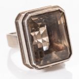 A SILVER CITRENE RING - KURT JOBST Bezel-set to the centre with an emerald-cut citrene weighing