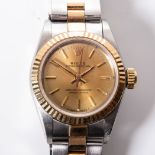 A LADY'S GOLD AND STEEL ROLEX OYSTER PERPETUAL WRISTWATCH reference no 67193, the circular gold dial