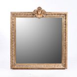 A GILT MIRROR The square plate within a conforming moulded frame, surmounted by a carved acanthus