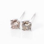 A PAIR OF DIAMOND STUDS claw set with two round brilliant cut diamonds weighing 0,60 carats together