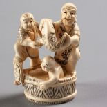 A JAPANESE IVORY NETSUKE OF A FIGURAL GROUP, MEIJI PERIOD, 1868 - 1912