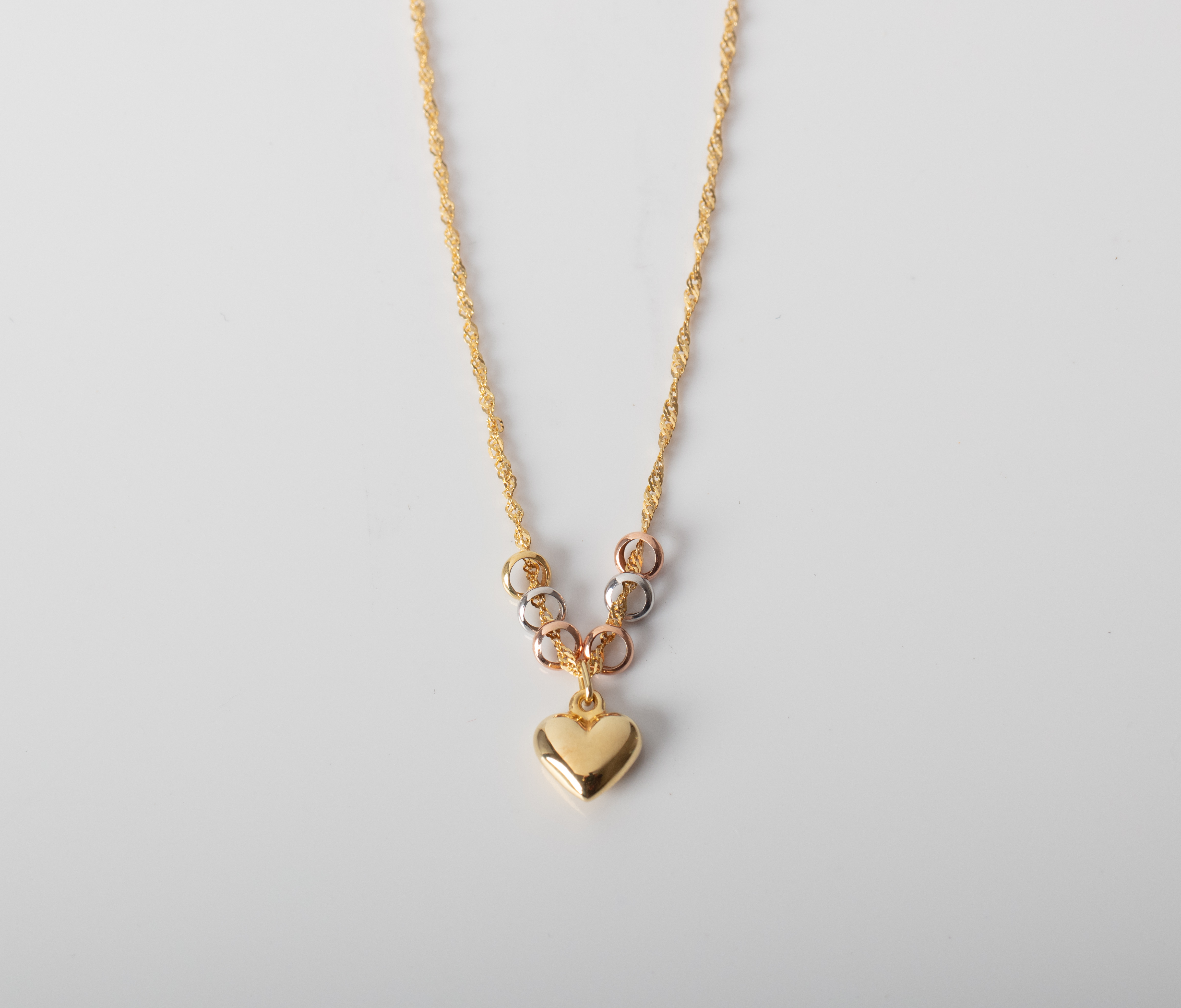 A 14CT AND SILVER BONDED HEART AND LUCKY RINGS NECKLACE