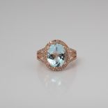 A 9CT ROSE GOLD AQUAMARINE AND DIAMOND HALO DRESS RING