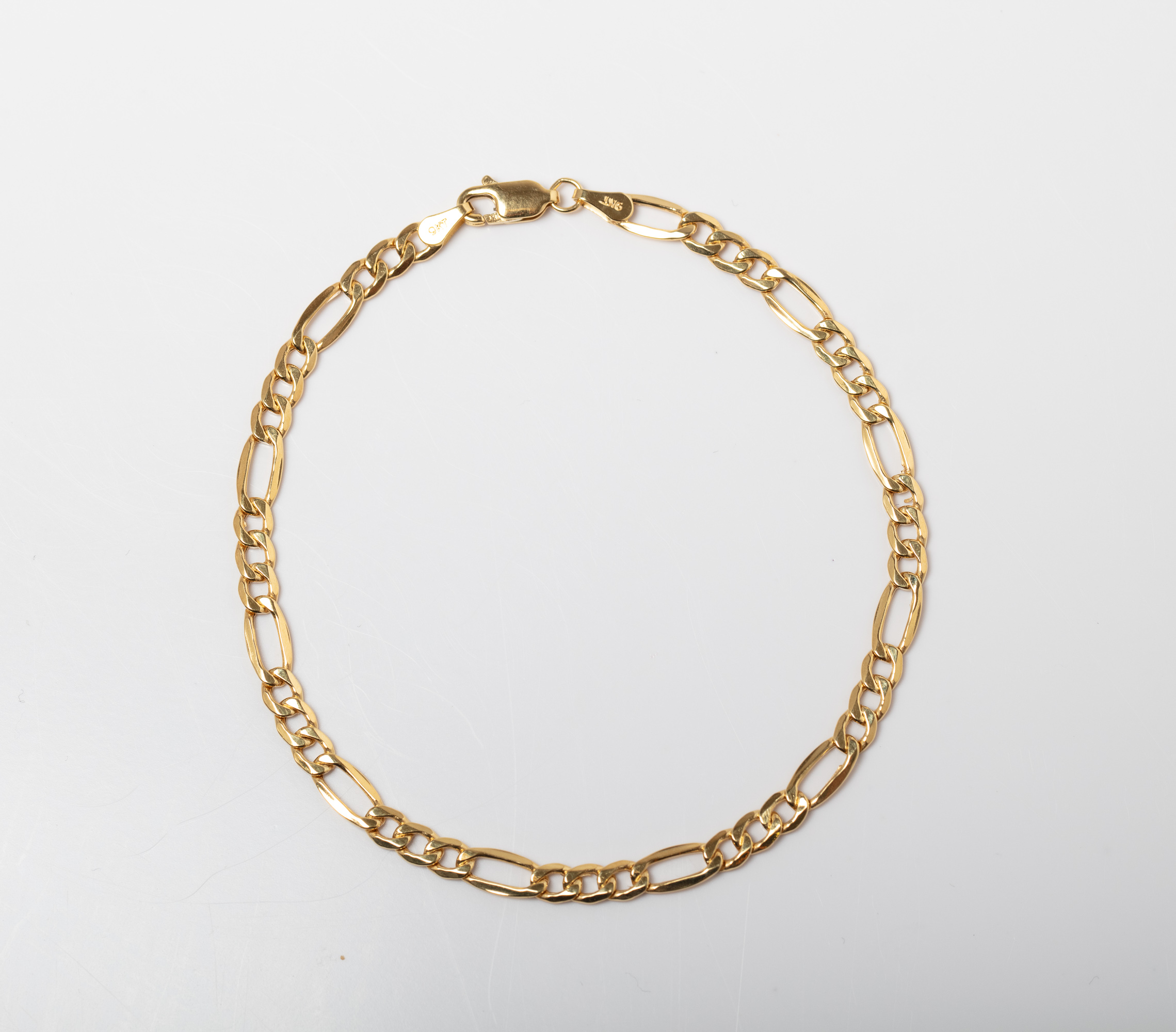 A 9CT GOLD FIGARO BRACELET