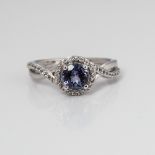 9CT WHITE GOLD TANZANITE AND DIAMOND HALO TWIST RING