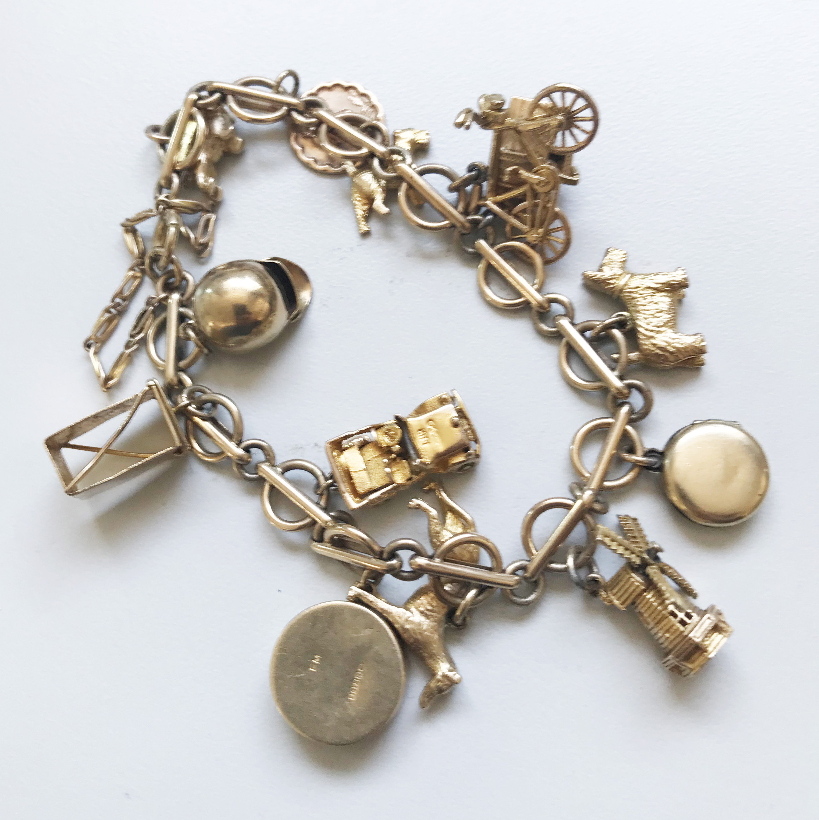 A 9CT GOLD CHARM BRACELET