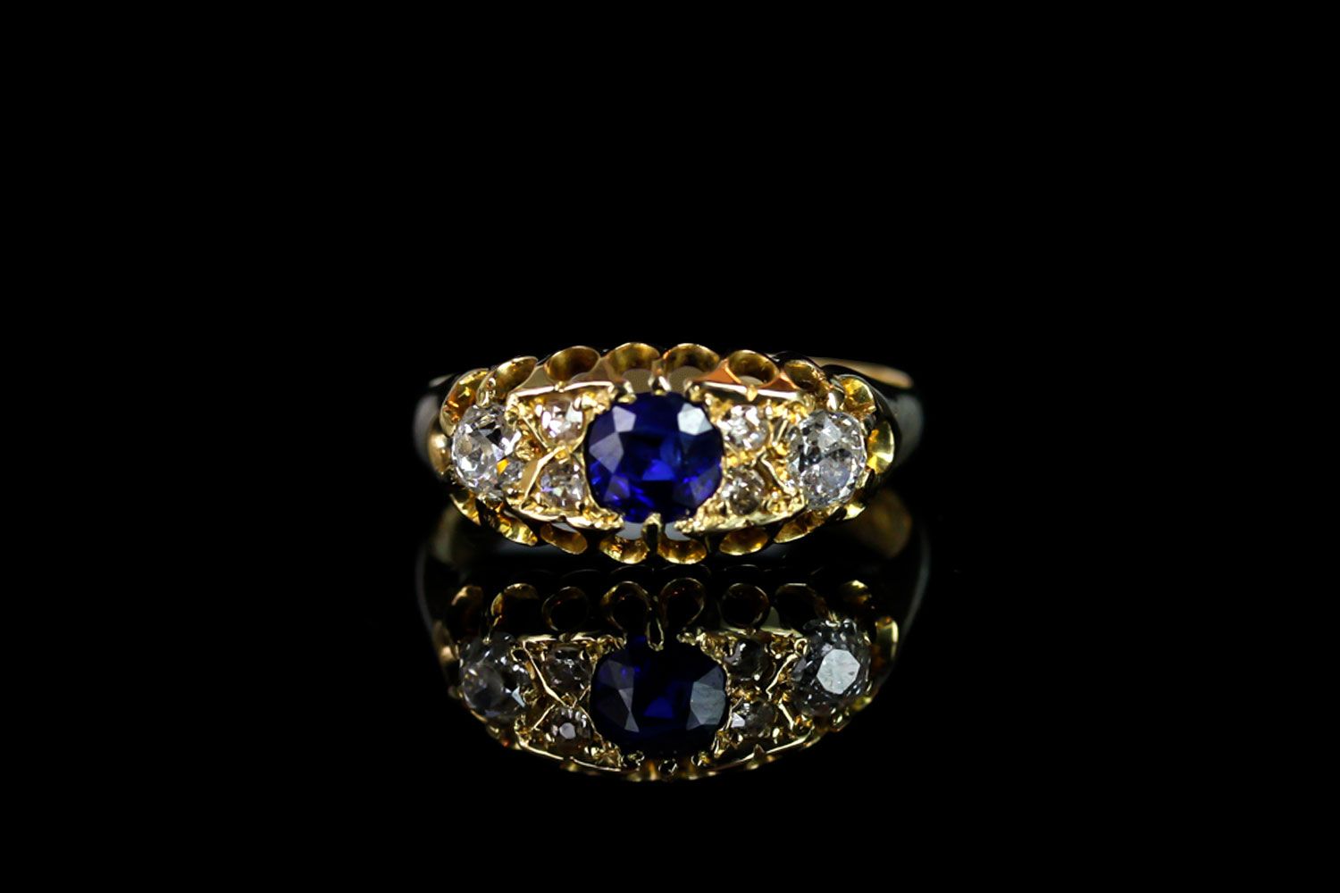 George V, Sapphire and Diamond carved half hoop ring, central 4.4mm blue sapphire, with old cut