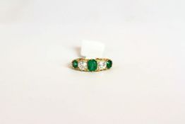 Early 20th Century curved half hoop ring, set with 3 emeralds totalling approximately 1.30ct, set