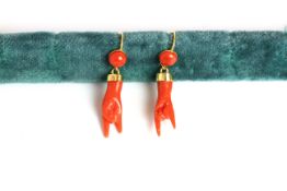 Pair of Coral drop earrings, set with coral carved into a rock hand shape, fish hook style.