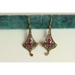 Pair of Ruby and Diamond flared drop earrings, each set with 6 rubies and 14 diamonds, approximate