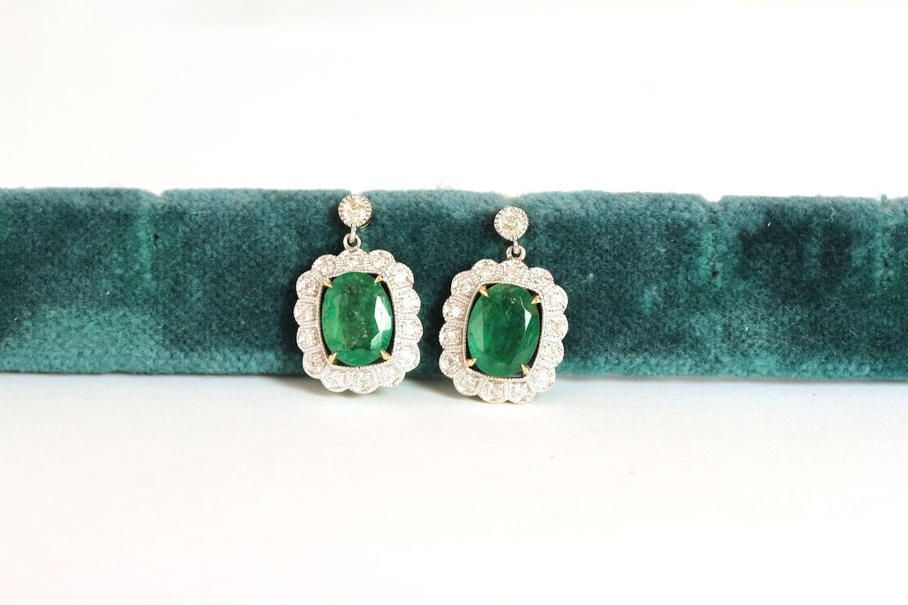 Pair of Emerald and Diamond drop earrings, set with 2 oval cut medium green emeralds