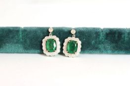 Pair of Emerald and Diamond drop earrings, set with 2 oval cut medium green emeralds