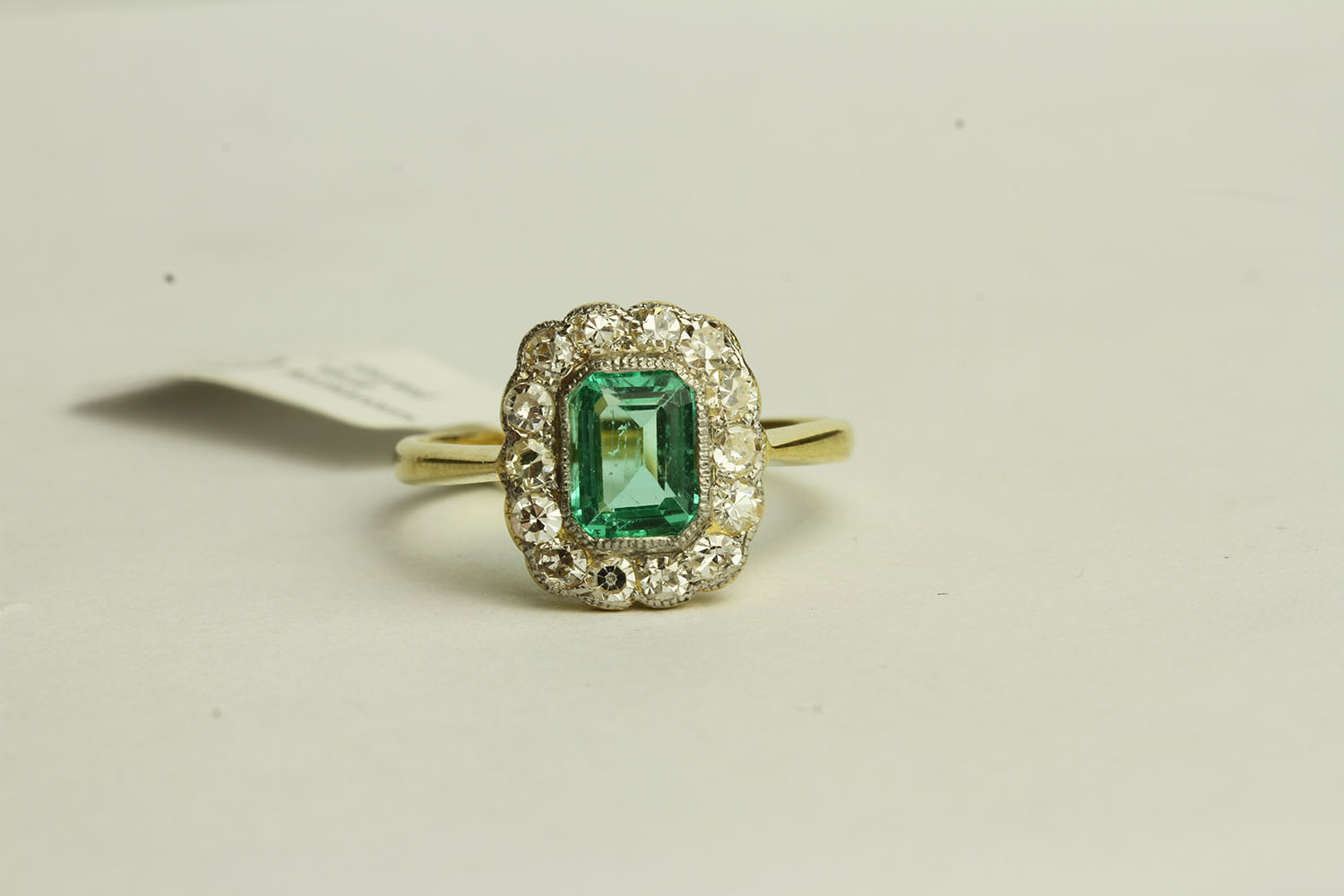 Emerald and Diamond Ring, set with a centre emerald approximately 0.64ct, surrounded by 14