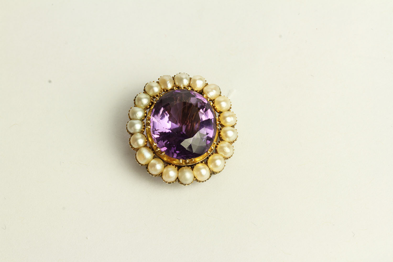 Amethyst and Pearl Brooch, set with a centre amethyst, surrounded by pearls.