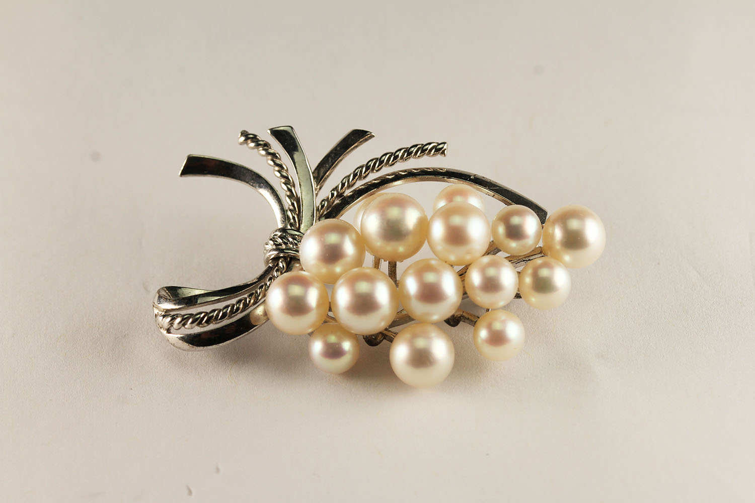 SILVER VINTAGE MIKIMOTO PEARL BROOCH, dimensions 45x25mms , set with 15 stones of various sizes