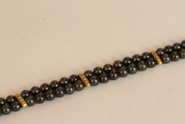 HAEMATITE TWO ROW BRACELET WITH YELLOW METAL DIAMOND SET BARS AND CLASP, black stones estimated as