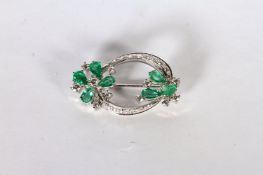 14CT WHITE GOLD EMERALD AND DIAMOND BROOCH ,PRONG SET AND STYLED AS TWO FLOWERS WITH EMERALD