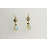 Pair of Opal Drop Earrings, each set with an oval cut opal, claw set, fish hook style.