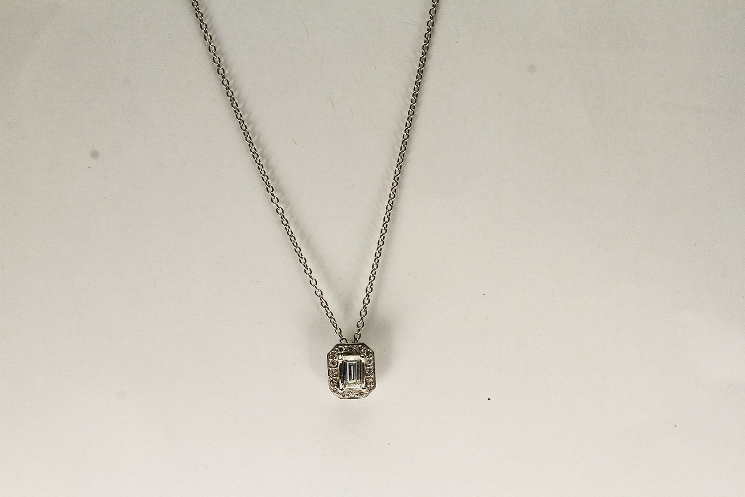 18CT WHITE GOLD EMERALD CUT DIAMOND NECKLACE ESTIMATED AS 0.51CT CENTRE STONE, estimated colour G,