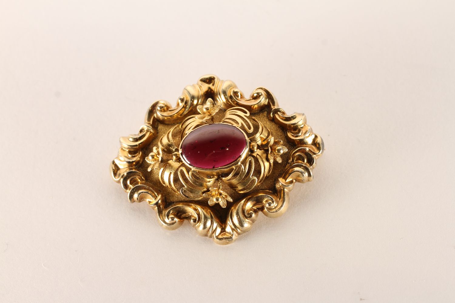 Victorian Brooch, Cabochon garnet centre floral gold work detail, approximately 8.6g gross, tested