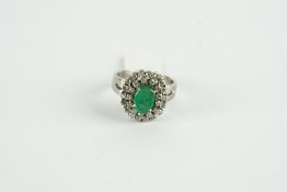 18CT WHITE GOLD EMERALD AND DIAMOND CLUSTER RING,centre stone estimated as 9.2x 3.48mm, diamonds