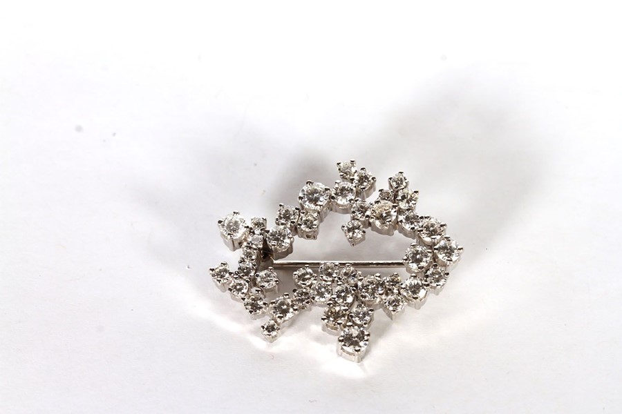 14CT DIAMOND BROOCH FORMED AS AN ABSTRACT SHAPED COCKTAIL BROOCH, set with an estimated 42 round