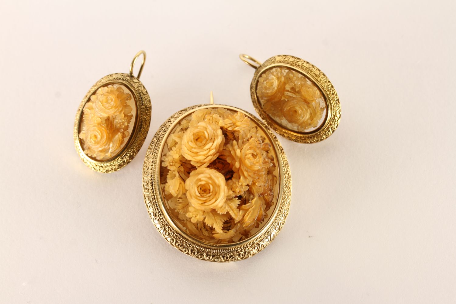 18ct carved floral brooch and earring set, carved cameo of floral design, detailed scroll work to
