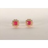Pair of Ruby and Diamond Flower Stud Earrings, set with a a total of 2 pinkish red rubies