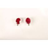 Pair of 18ct white gold ruby and diamond studs with rubberised butterflies. Oval-cut rubies 4.