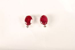 Pair of 18ct white gold ruby and diamond studs with rubberised butterflies. Oval-cut rubies 4.