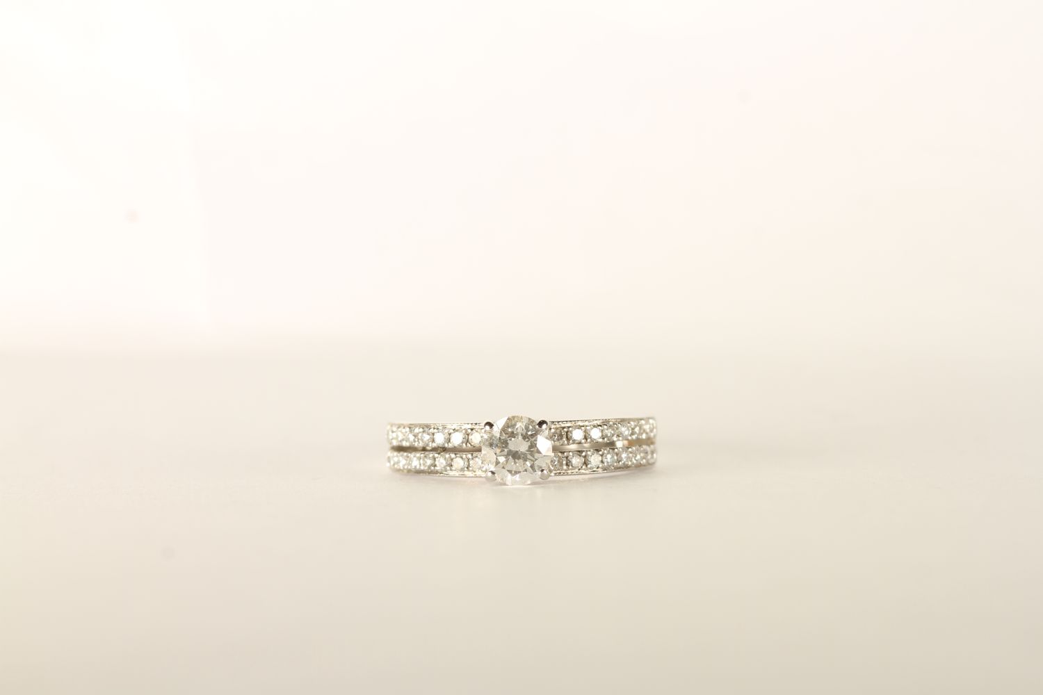 Diamond Ring, centre set with a round brilliant cut diamond, 4 claw set, shoulders set with 2 rows