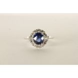 18ct white gold sapphire and diamond cluster ring. Oval-cut sapphire 1.75ct. RBC diamonds 0.40ct.
