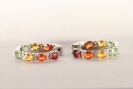 Pair of Multi-Coloured Sapphire and Diamond Hoop Earrings, set with a total of 14 oval cut yellow,