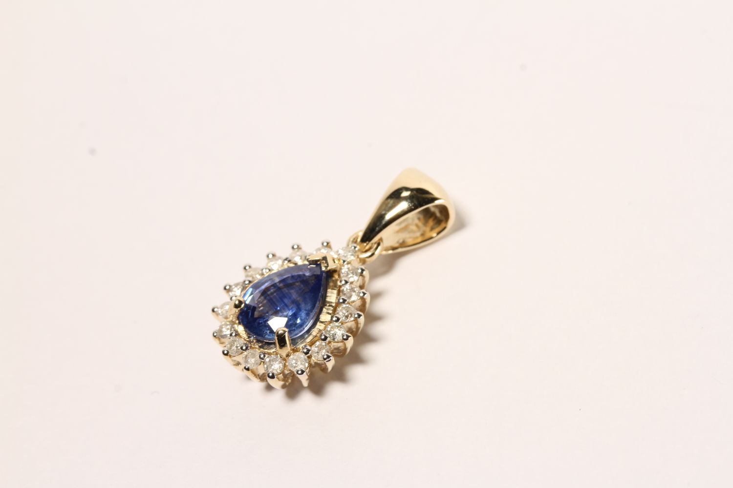 Sapphire and Diamond Pendant, set with a pear cut medium blue sapphire totalling 1.20ct, claw set,