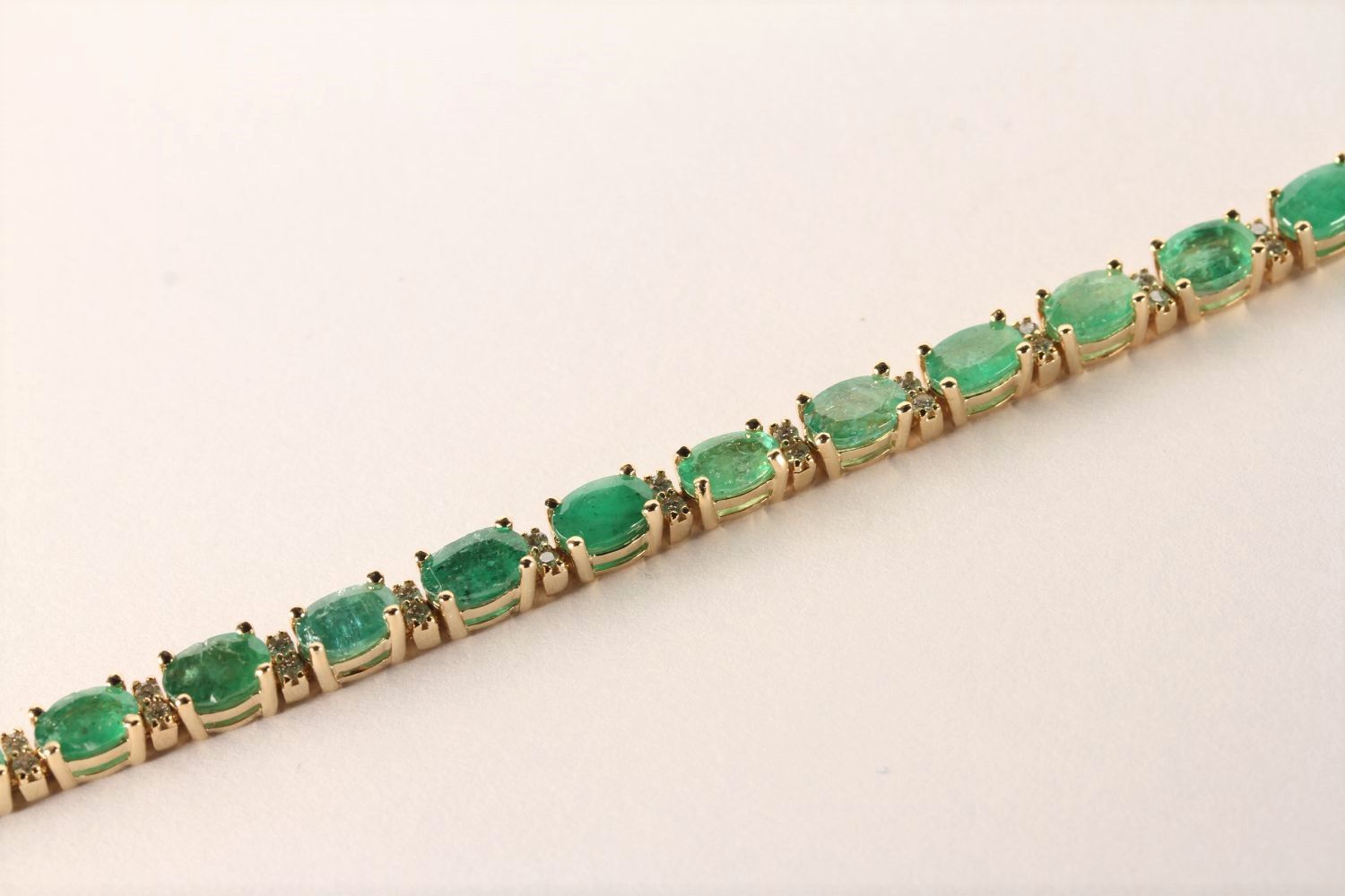 Emerald and Diamond Bracelet, set with 22 oval cut medium green emeralds totalling 7.02ct, claw set,