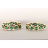 Pair of Emerald and Diamond Hoop Earrings, set with a total of 18 oval cut medium to dark green