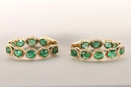 Pair of Emerald and Diamond Hoop Earrings, set with a total of 18 oval cut medium to dark green